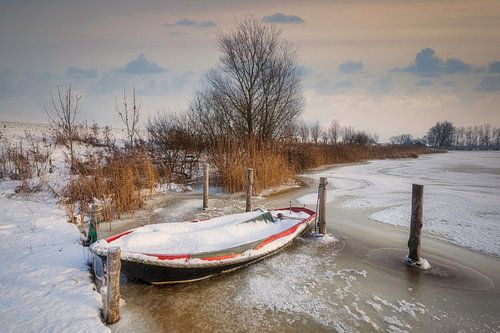 Winter landschap met roeiboot in het ijs