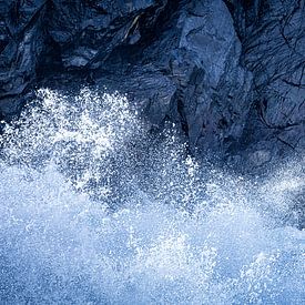 Die Wellen brechen an den blauen Felsen von Jose Gieskes