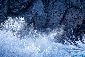 Die Wellen brechen an den blauen Felsen von Jose Gieskes