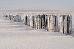 Ruhe am Strand: Wellenbrecher verschwinden im Sand