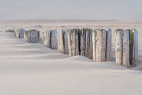 Rust aan het strand: Golfbrekers verdwijnen in het zand