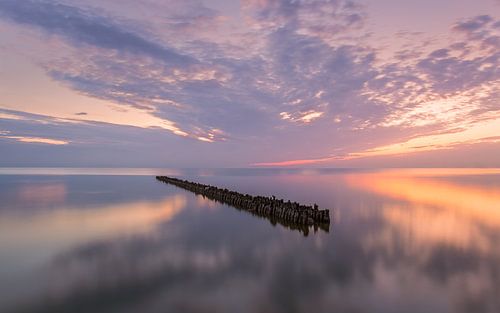 Paaltjes in het IJsselmeer bij Hindeloopen op een mooie zomeravond en zonsondergang