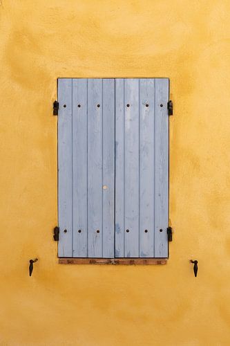 Volets bleus sur un mur ocre dans le village de Villedieu en France