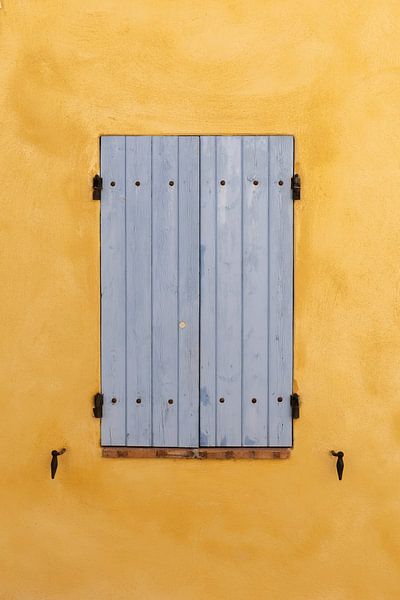 Blaue Fensterläden an einer ockerfarbenen Wand in dem Dorf Villedieu in Frankreich von Cindy Mulder