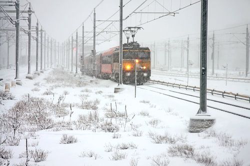 Rijdende trein in de sneeuw bij Amsterdam in Nederland