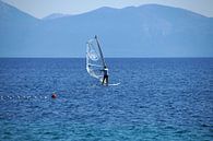 windsurfer wit met doorzichtig zeil surfend in het blauw landschap van wil spijker thumbnail