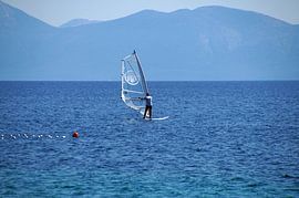 lone windsurfer white in blue landscape