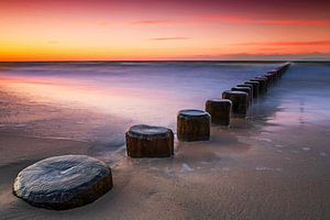 Buhnen am Meer im Sonnenuntergang