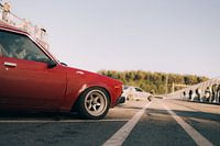 Roter Toyota Corolla Oldtimer Seitenansicht bei Sonnenuntergang
