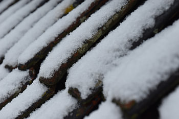 toit en tuiles recouvert de neige