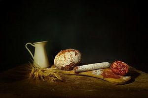 Stilleben mit Brot, Salami und Granatapfel.