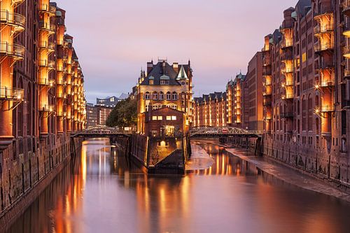 Speicherstadt Hamburg met de waterburcht. Lichtjes schijnen in de schemering.