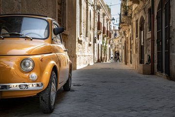 Een oude gele Fiat 500 in het centrum van Syracusa, Sicilië, Italië. van Ron van der Stappen