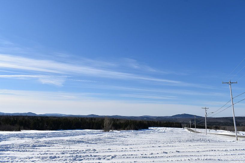 A field in winter under blue skies by Claude Laprise