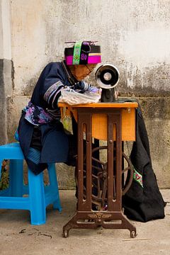 Frau in traditioneller Kleidung aus China näht Kleidung an der Nähmaschine von Cindy Mulder
