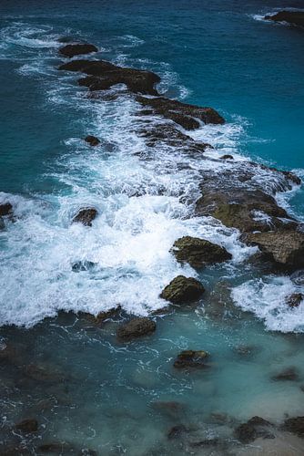 Kolkend water wat over de stenen heen gaat in de Blue Lagoon op Nusa Ceningan Bali