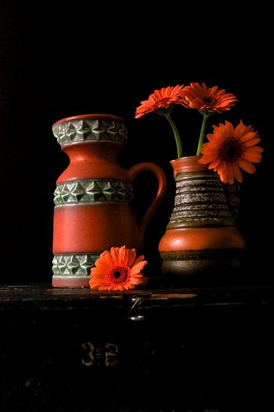 Abbildung von Vasen aus den 70er Jahren mit orangefarbenen Gerberas. von Therese Brals