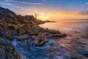 Insel Menorca mit Leuchtturm im Sonnenuntergang. 