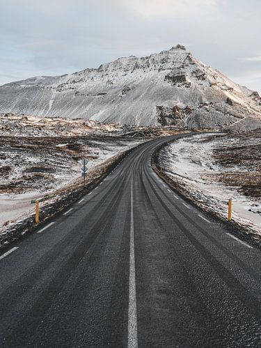 Ijslandse ringweg langs de Arnarstapi op het Snaefellsnes schiereiland bij zonsopkomst en sneeuw