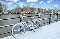 Besneeuwde fiets aan de Amstel in Amsterdam Nederland in de winter by Eye on You thumbnail