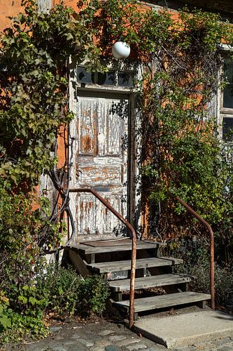 Malerischer Eingang mit alter verwitterter Tür und Treppe