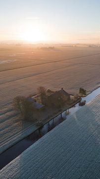 Winterlicher Sonnenaufgang über einem friesischen Bauernhof von Ewold Kooistra