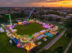 Jahrmarkt bei Sonnenuntergang mit beleuchteten Schaustellern