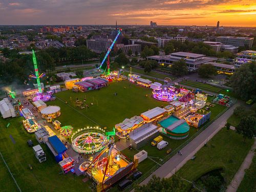 Kermis tijdens zonsondergang met verlichte kermisattracties