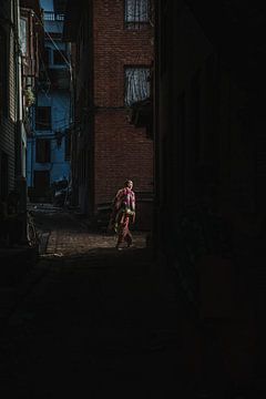 Vrouw loopt in de straten van Bhaktapur Nepal van Ayla Maagdenberg