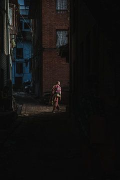 Une femme marche dans les rues de Bhaktapur, au Népal. sur Ayla Maagdenberg