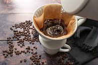 Gebrühter Kaffee, Aufgießen von heißem Wasser auf gemahlenen Kaffee in einem Filter auf einem Becher von Maren Winter Miniaturansicht