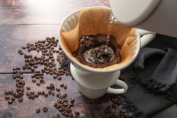 Gebrouwen koffie, heet water gieten op gemalen koffie in een filter op een mok voor een stimulerend 