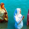 Trois femmes en prière (puja) dans le Gange près de Varanasi, en Inde sur Jan Fritz