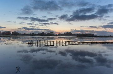 Wolken spiegeling bij zonsondergang van Marcel Kerdijk