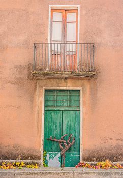 Old balcony and green door autumn in Atzara, Sardinia