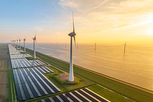 Windturbinen und Sonnenkollektoren an einem Seeufer
