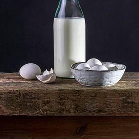 Still life of bottle of milk, eggs on a bench of old oak monastic parts by Susan Chapel