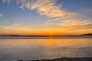 Goldene Wolkenformationen über dem flachen Uferwasser
