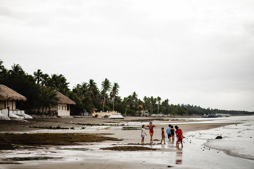 Children on the beach in fishing village in Philippines by Yvette Baur