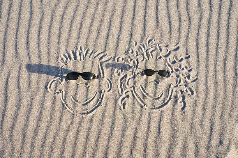 faces drawn in the sand on the beach of the Baltic Sea by Martin Köbsch