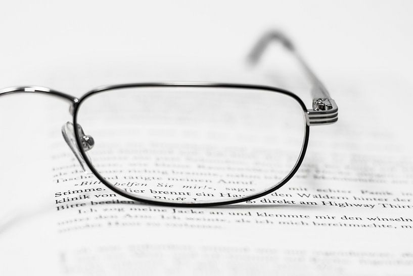 Reading glass and book by Rico Ködder