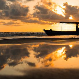 Zonsondergang op het strand met bootje van Iris Hagemans