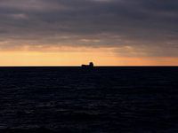 Zonsondergang met silhouette van containership in Canada