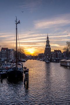 Schepen voor de  Montelbaanstoren  tijdens de zonsondergang in Amsterdam.