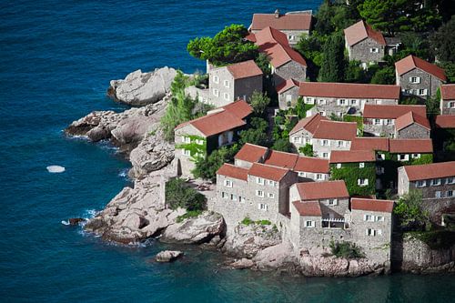 Mediterrane stad. kleine huizen met een pannendak en groene bomen aan de blauwe zee. geluk in ontspa