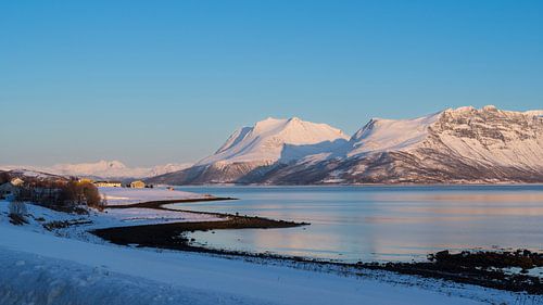 Zicht op het eiland Senja in het poolgebied van Noorwegen met fjord en zee en bergen met sneeuw, Tro