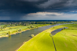 Die Landschaft an der IJssel an einem Sommertag mit dunklen Gewitterwolken