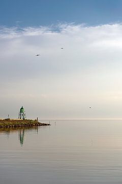De groene vuurtoren van de haven van Stavoren op een windstille avond van Harrie Muis