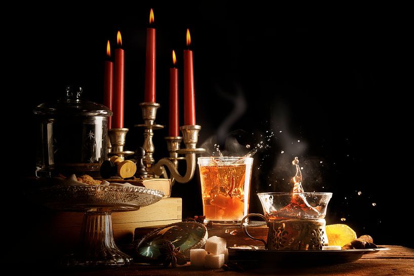 Un thé chaud avec des éclaboussures et de la vapeur, des bougies et des sucreries rendent la sombre  par Maren Winter