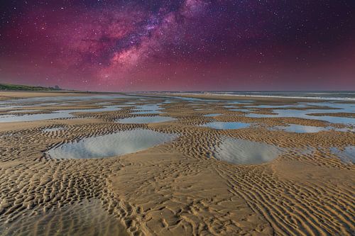 Nachtscène met heldere sterrenhemel boven verlaten kustlandschap met duinen, zee en strand met achte